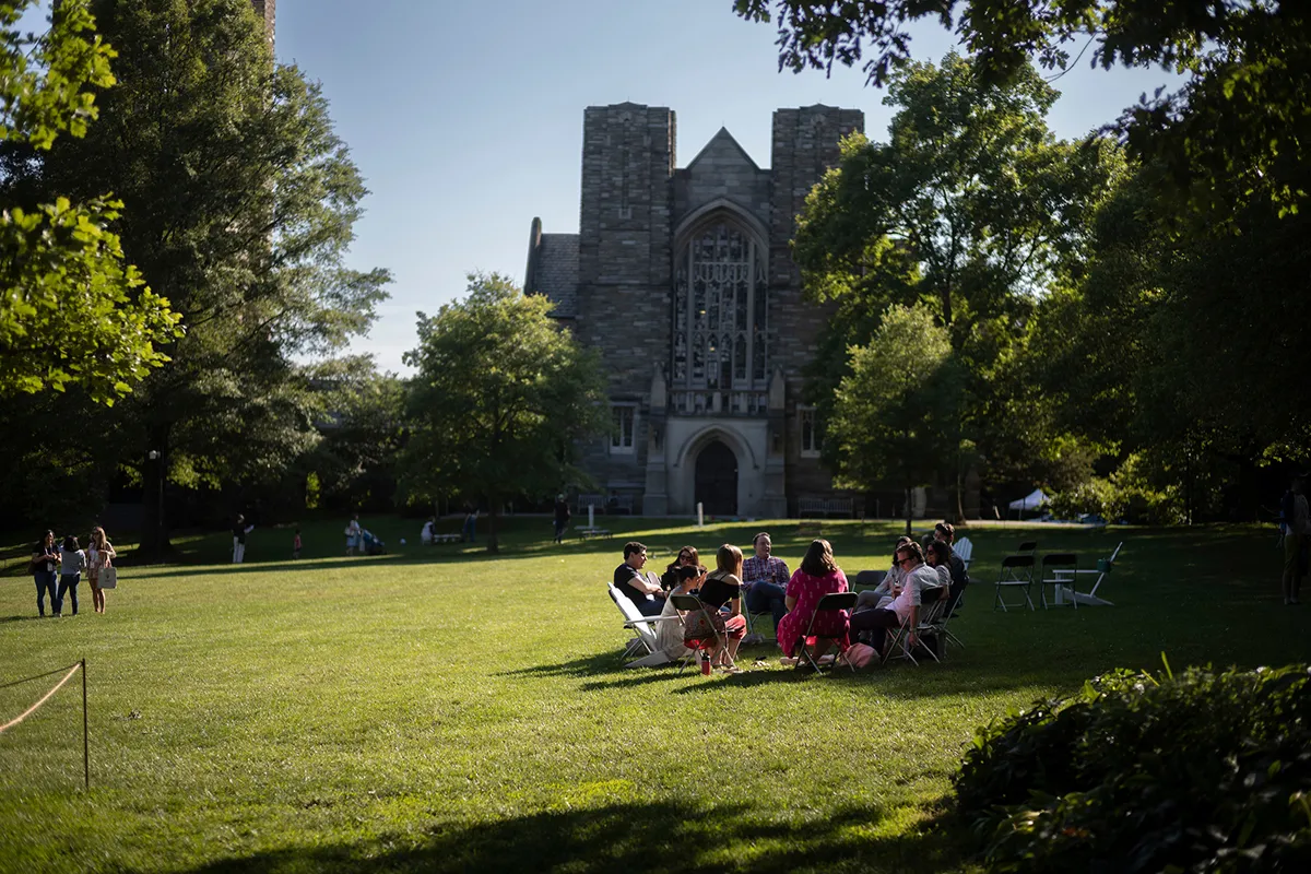 Group of people sit in chairs in a circle on Parrish Beach