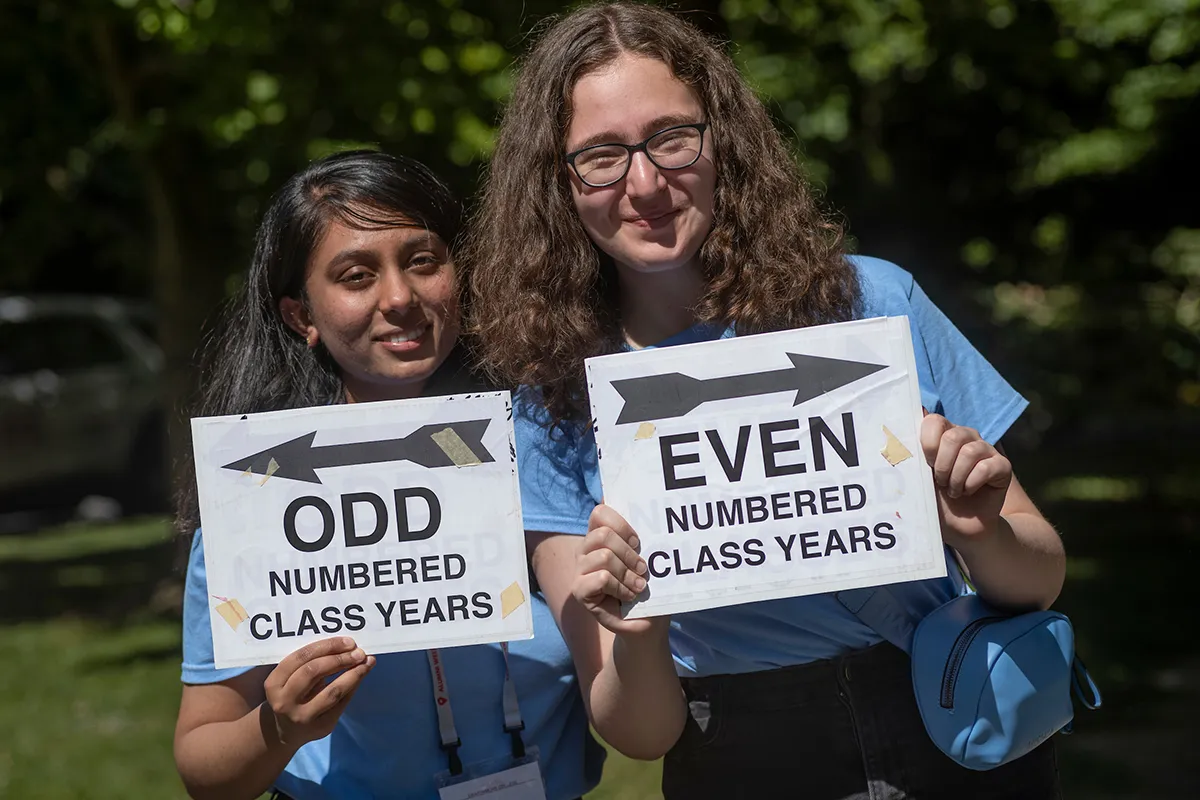 Two people hold signs that say "Odd" and "Even" with arrows pointing away from each other