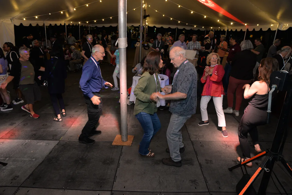 Alumni dance under tent during evening celebration