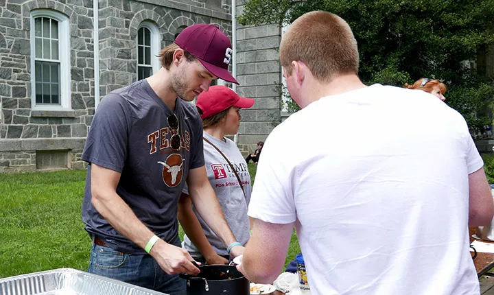 A man serves another man chili