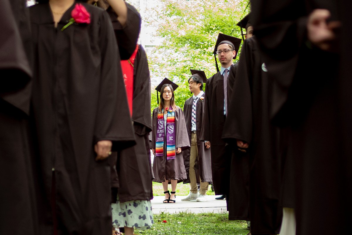 Students standing before Commencement