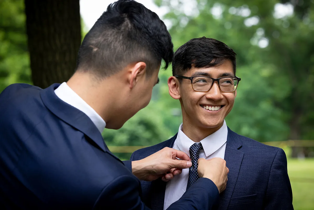 Student helps another student with tie