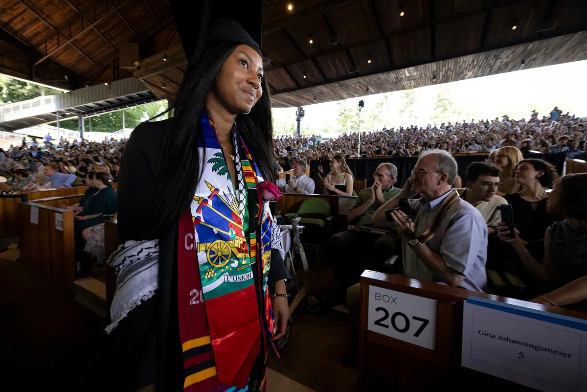 Student passes by crowd during commencement ceremony