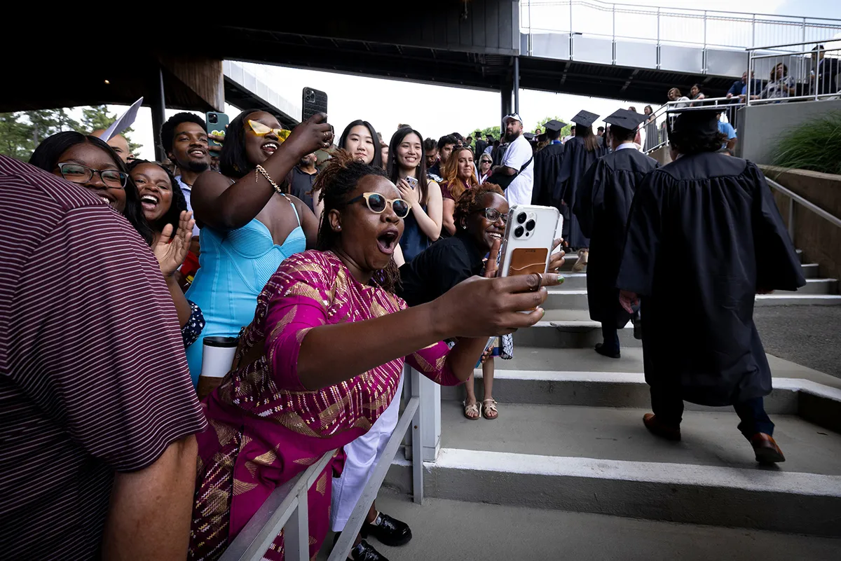 Parents cheer on graduating students as they pass by