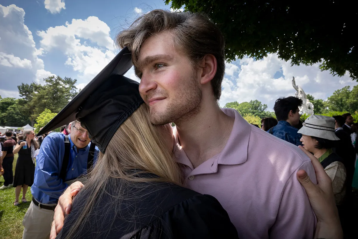 Student hugs family member after commencement ceremony