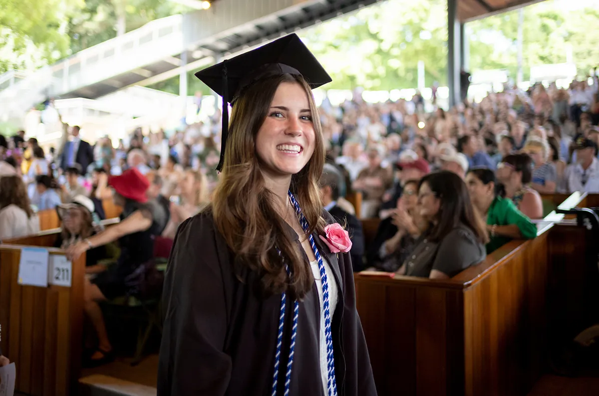 Student passes by crowd during commencement ceremony