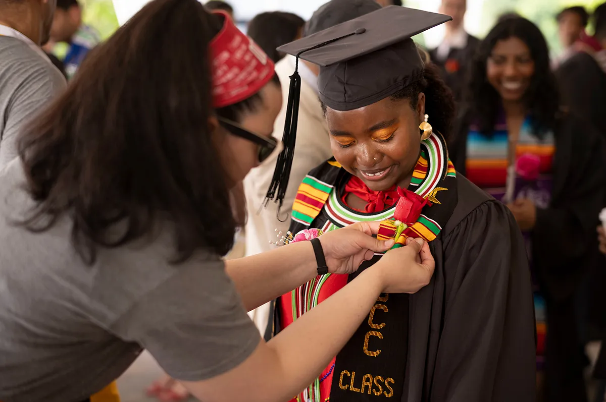 Staff member pins rose to graduate's stole