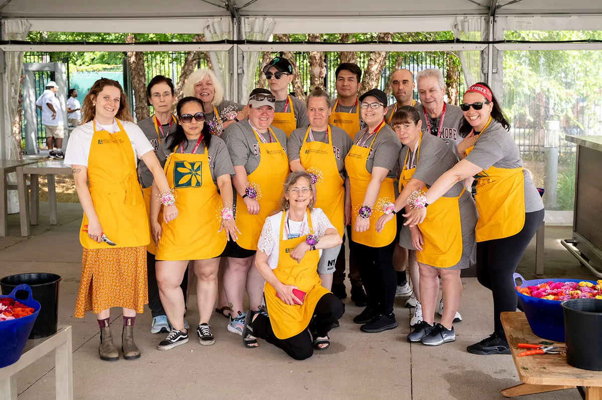 Arboretum staff wearing yellow aprons pose for group picture