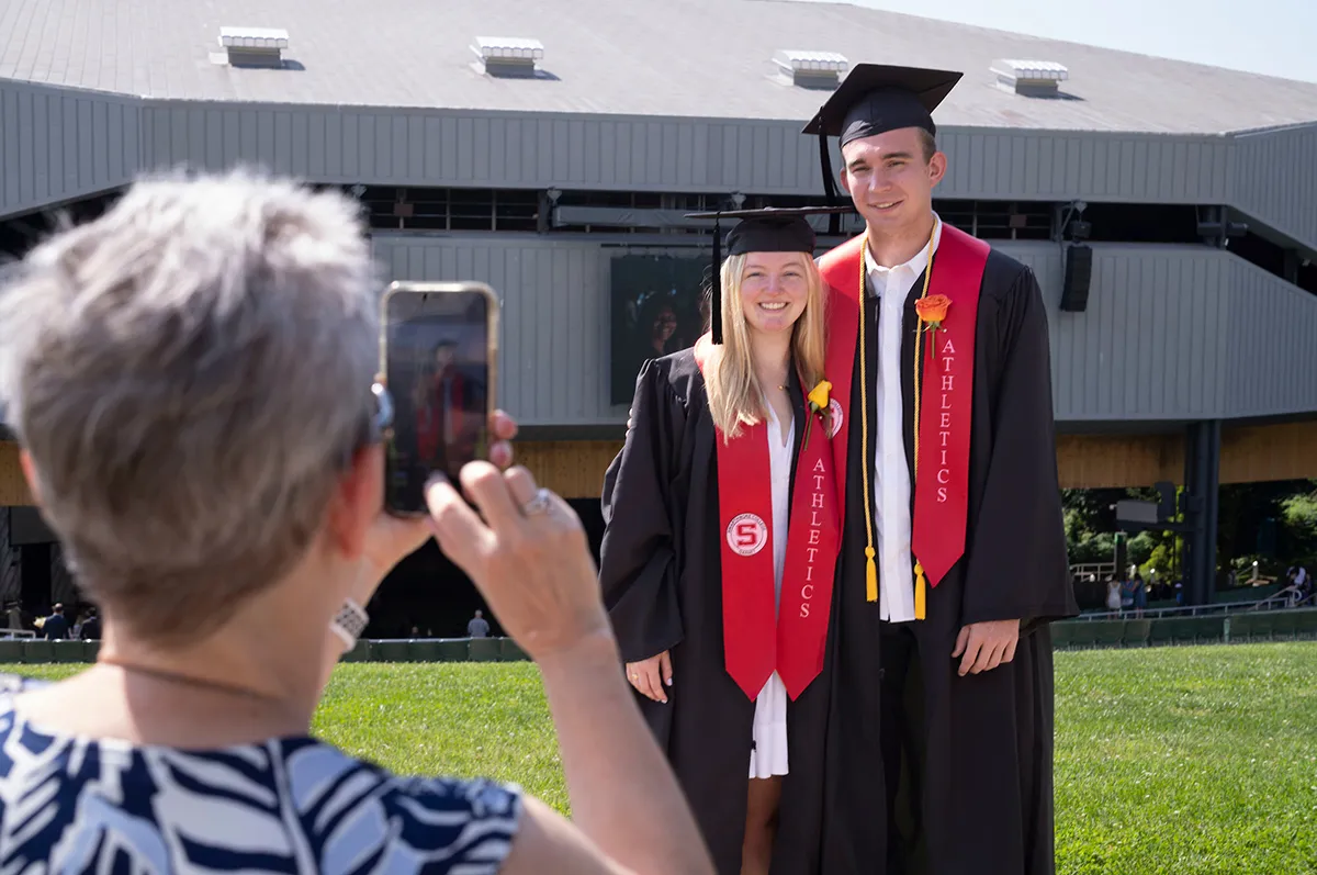 Two students pose for picture in front of Mann Center