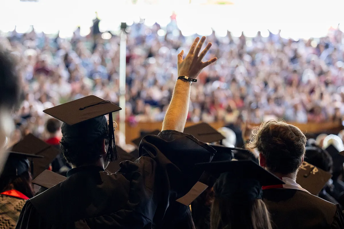 Students wave to family members during ceremony