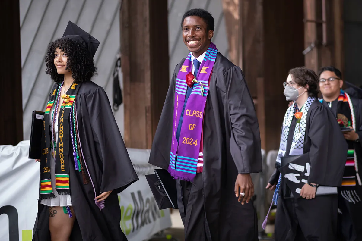 Students smile while exiting stage after commencement ceremony