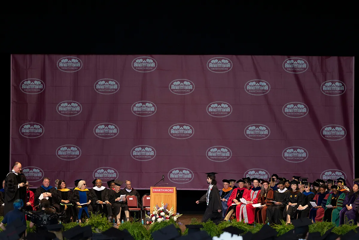 Student crosses stage to receive diploma during commencement