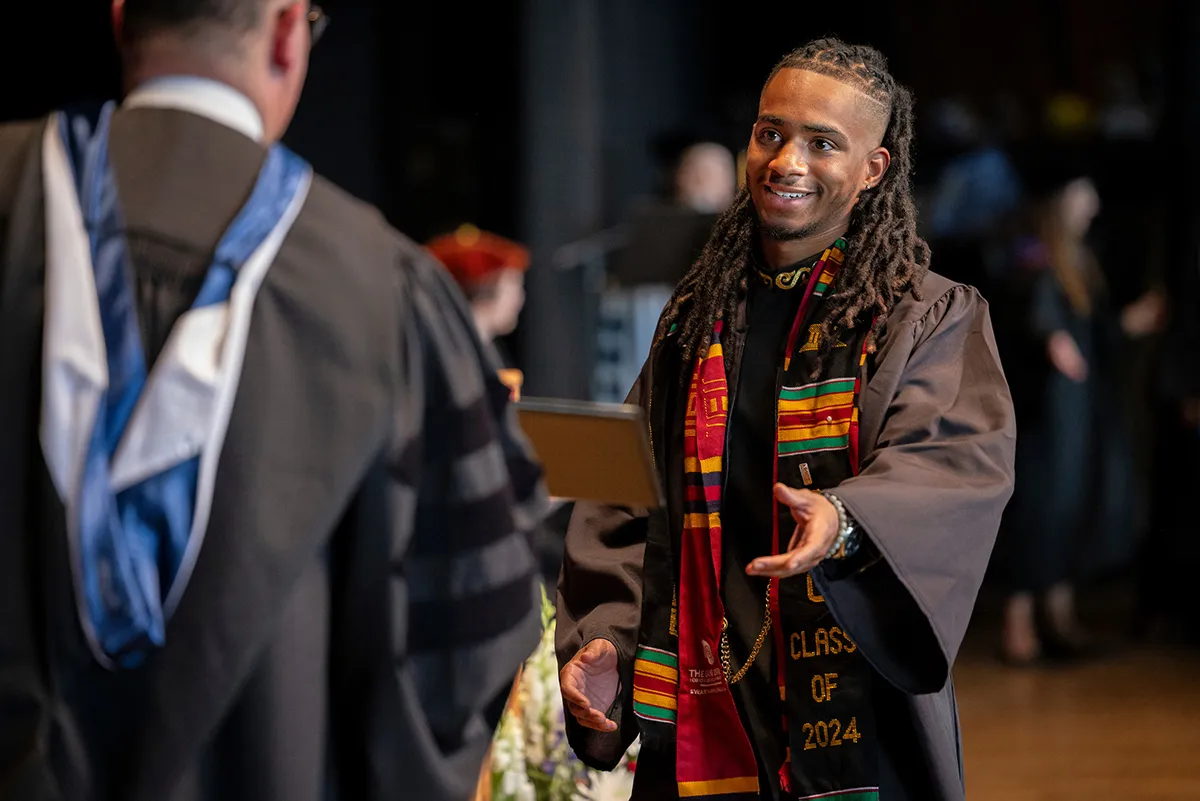 Student receives diploma from acting co-president Rob Goldberg