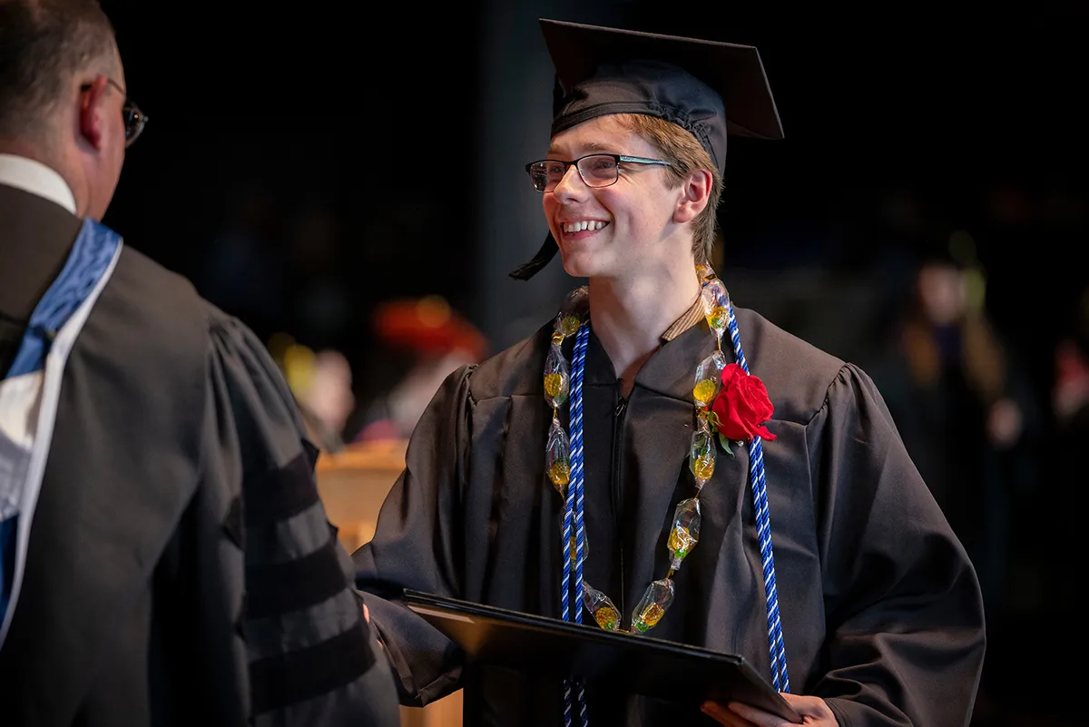 Student receives diploma from Acting Co-President Rob Goldberg