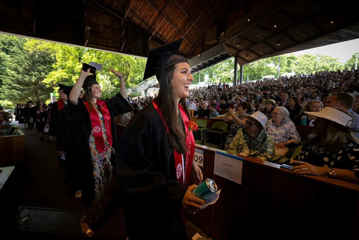 Student crosses stage in front of crowd