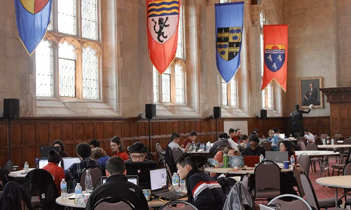 Students working on computers in the wood-paneled Thomas Great Hall