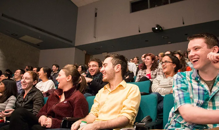 Students in the audience laugh