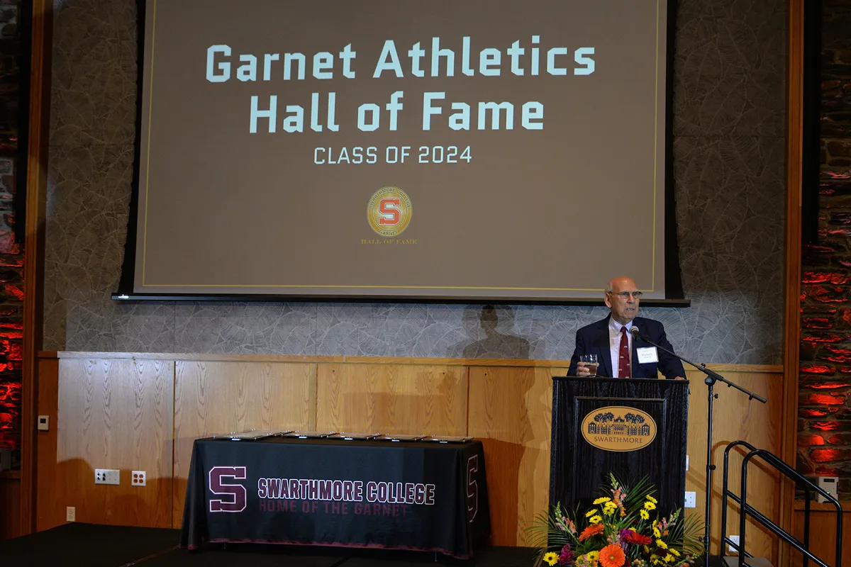 Person stands on stage and addresses audience at athletics hall of fame event