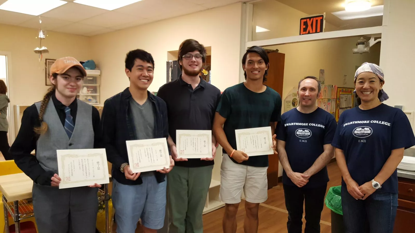 2017 graduating Japanese section students stand in a line, presenting certificates