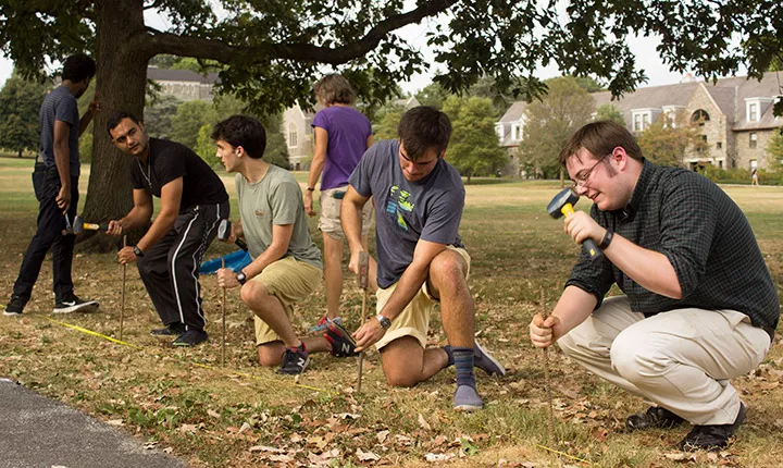 Students hammer stakes to place the memorials