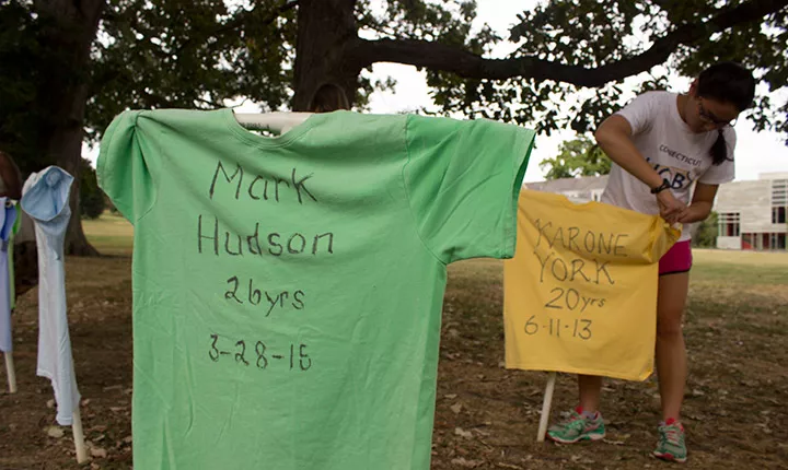 A student hangs a t-shirt memorial