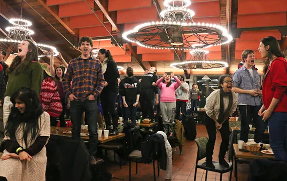 Students stand on top tables