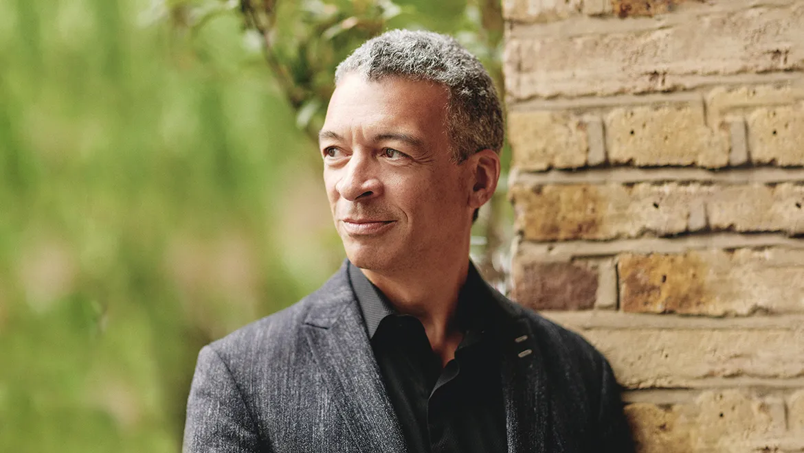 Roderick Williams standing in front of a green nature backdrop