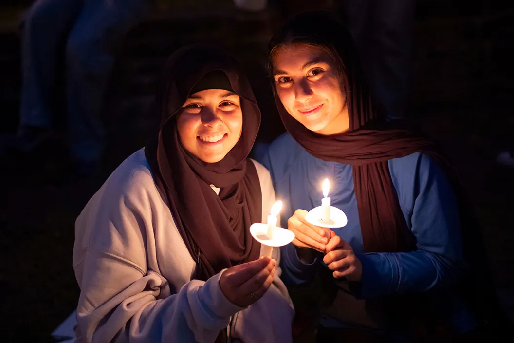 Two students hold candles during First Collection