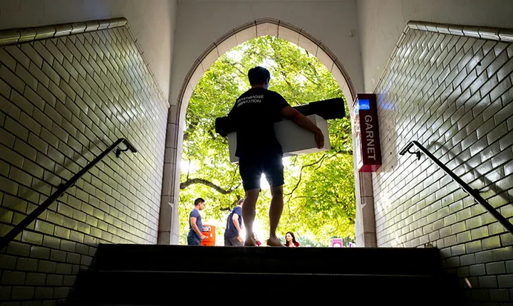 Student carries items into Wharton coutrtyard