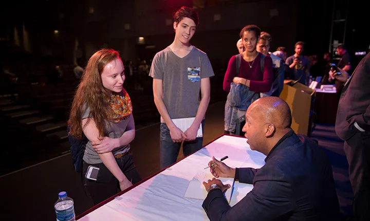 Bryan Stevenson signs a student's book following his lecture