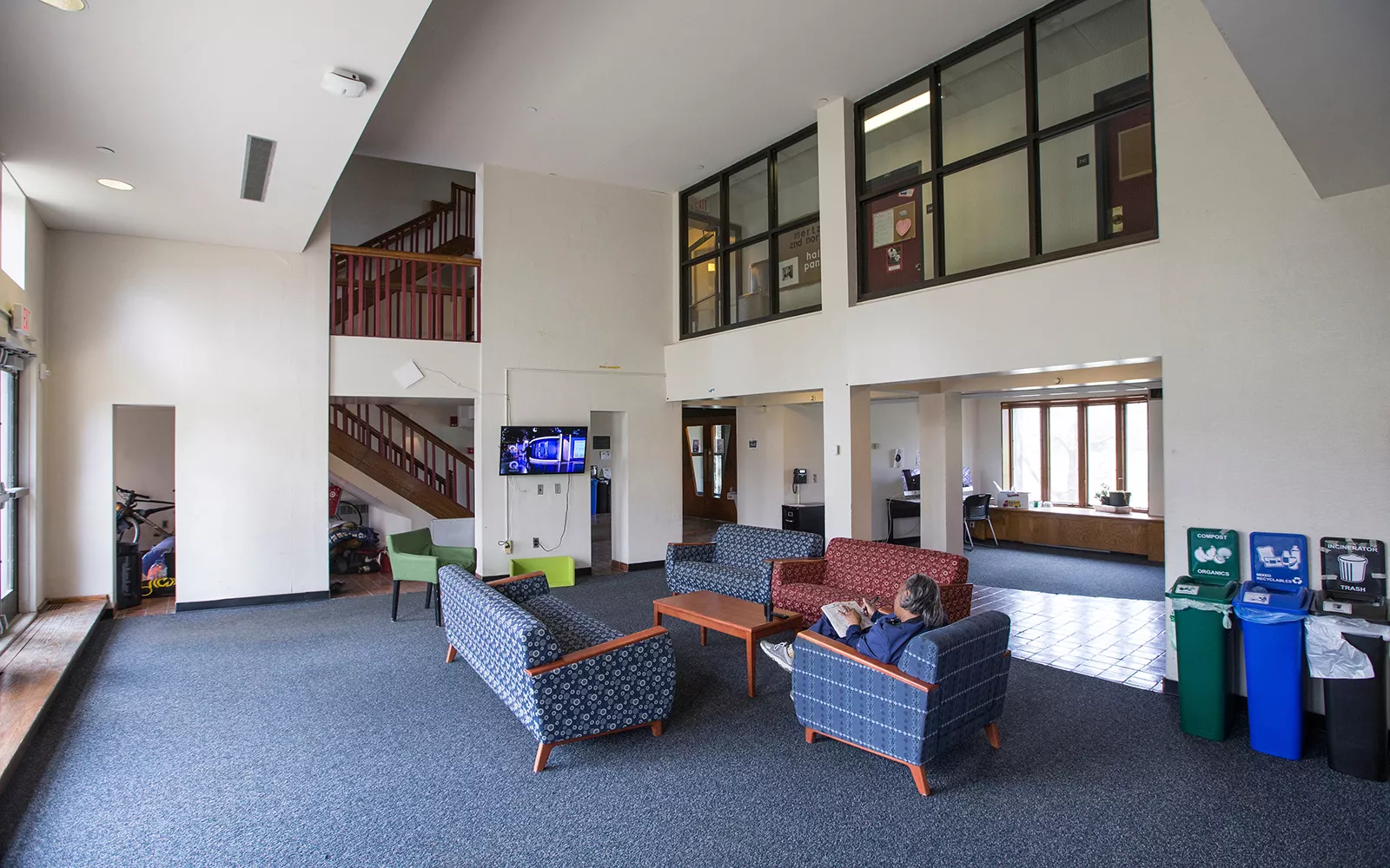 Lounge with high ceiling with blue chairs and blue carpet