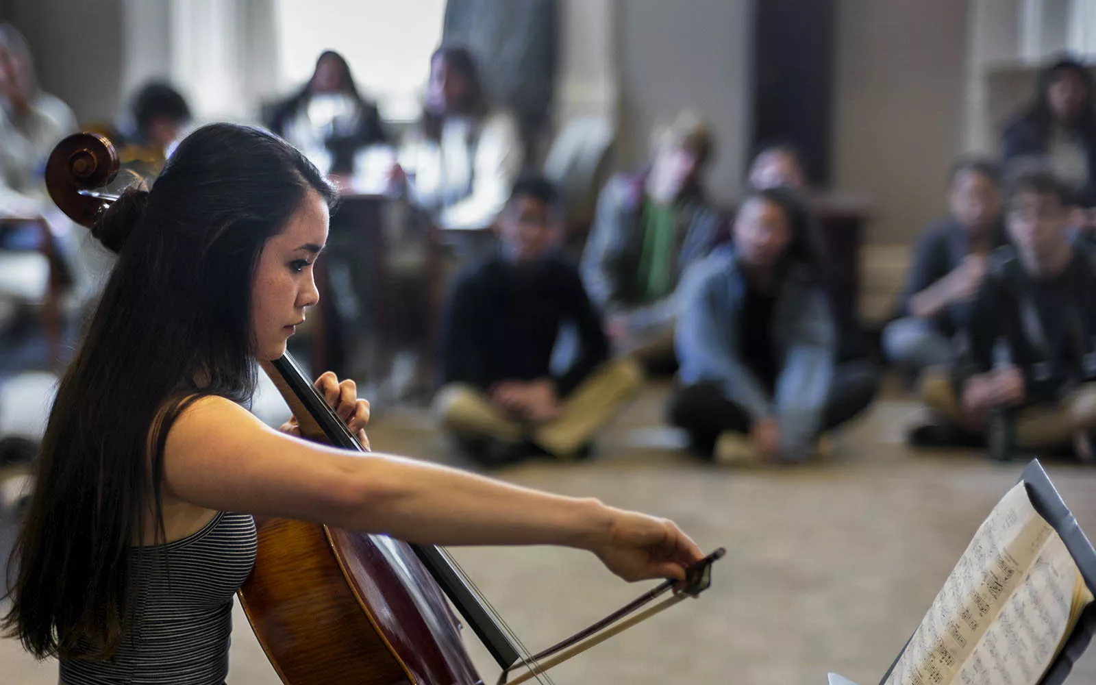 A student playing cello in Parrish Parlors