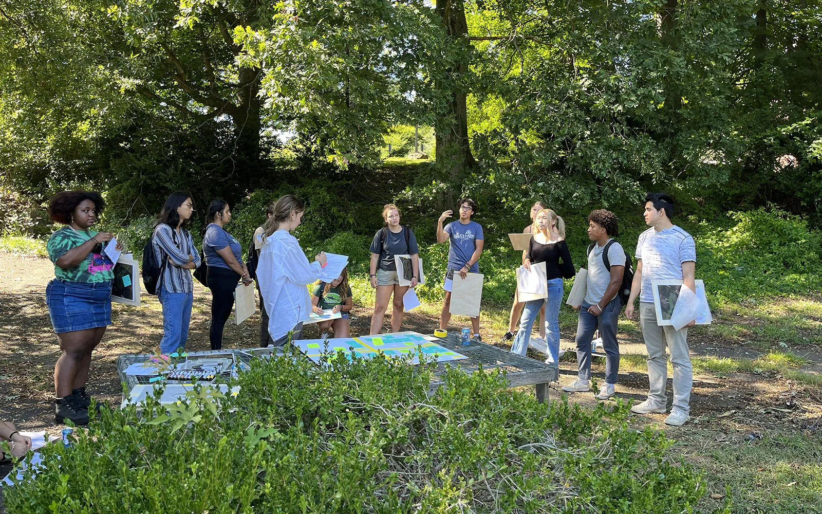 students in a park setting working on art