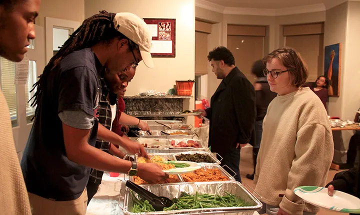 A student serves food at a Thanksgiving Dinner in the BCC