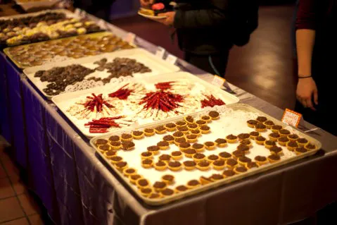 Students admire the food selection, including Treacle Tarts displayed in the shape of the Deathly Hallows