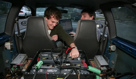 Two people working on electric car battery