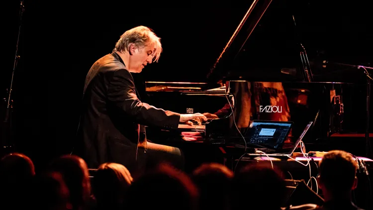 Hans Lüdemann on stage playing piano