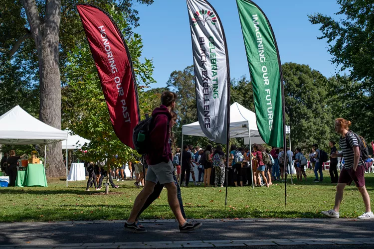 Students walk by Celebration of Black Excellence event