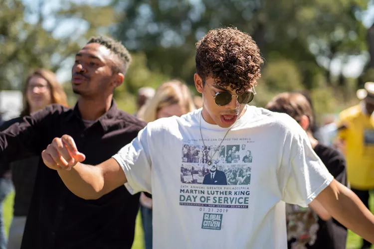 Student wearing sunglasses dances to music