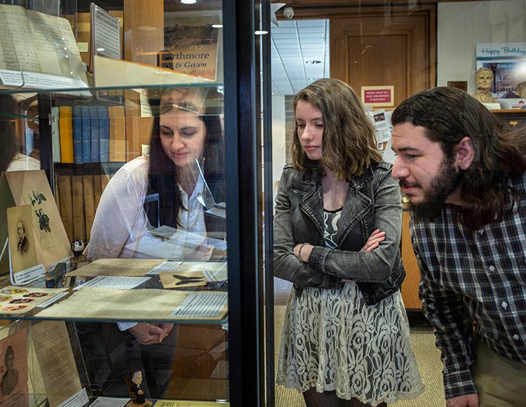 Library interns examine archival documents