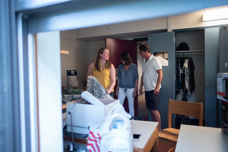 Student in dorm putting away clothes