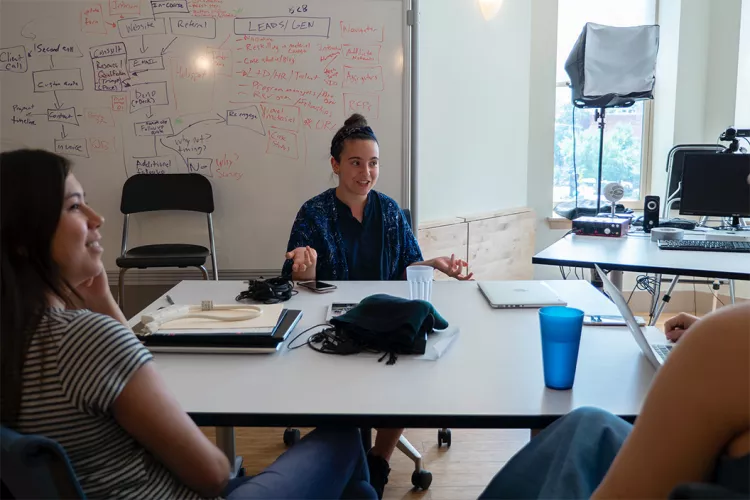 Nancy Awad '20 sits in front of whiteboard with diagrams