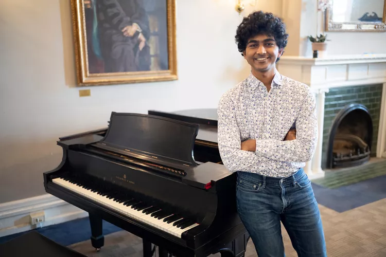 Person stands in front of piano inside