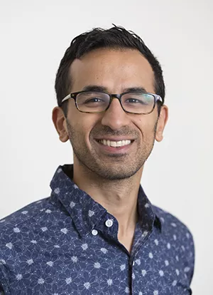 Syon Bhanot smiling against white background