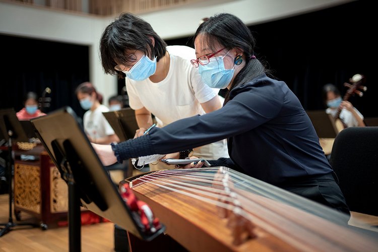 Students wearing masks play instrument