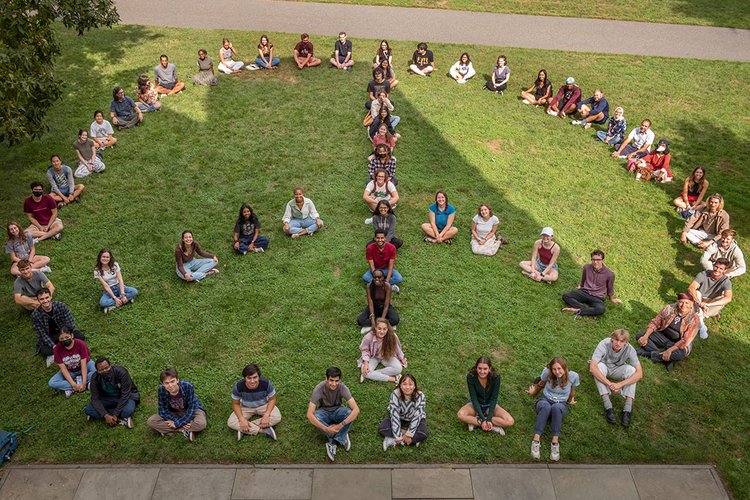 Students sitting on lawn form giant peace sign