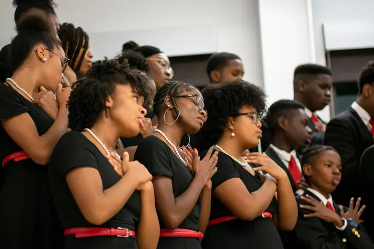 Girls in black dresses sing in chorus