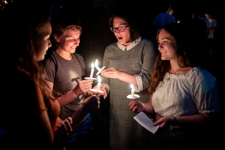 Students hold candles at first collection