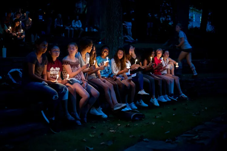 Students hold candles at first collection