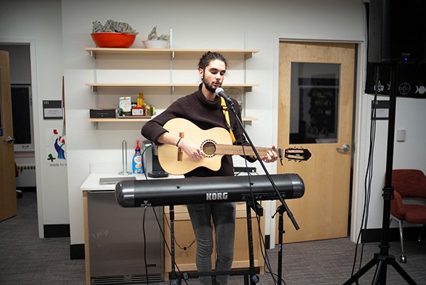 Student plays guitar at IC dedication event